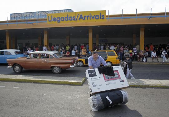 A passenger pushes a luggage cart after arriving on a charter flight from Tampa at the airport in Havana