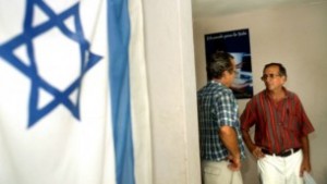 Una bandera israelí cuelga en la pared del centro de la comunidad judía en La Habana, Cuba, donde dos hombres están hablando. Foto de archivo del 01 de agosto de 2004. (Serge Attal / Flash90)